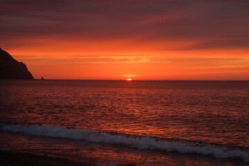 the red sun rises over the sea