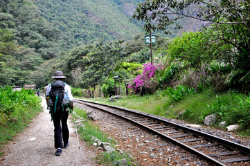 Hikers walking along the railroad tracks in the jungle near Aguas Calientes, the gateway to Machu...