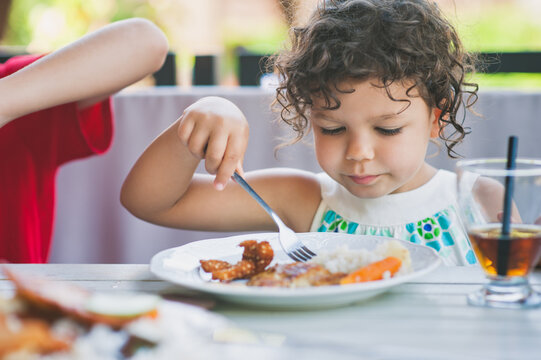 Child having a meal outdoors in summer.