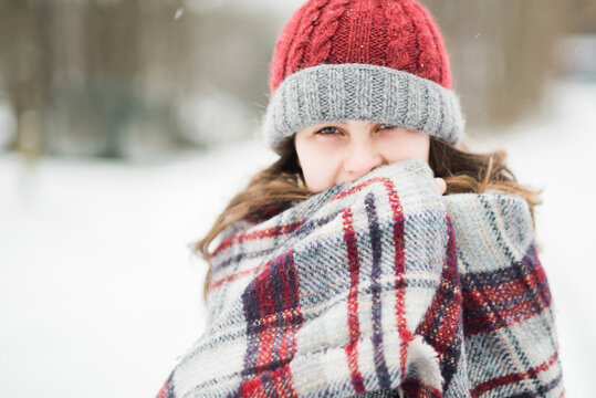 young woman wrapped in blanket in the snow