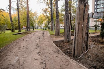Fototapeta premium Repair of paths in parks. Protection of trees in the reconstruction of Park areas. Construction equipment works on the repair of the road.