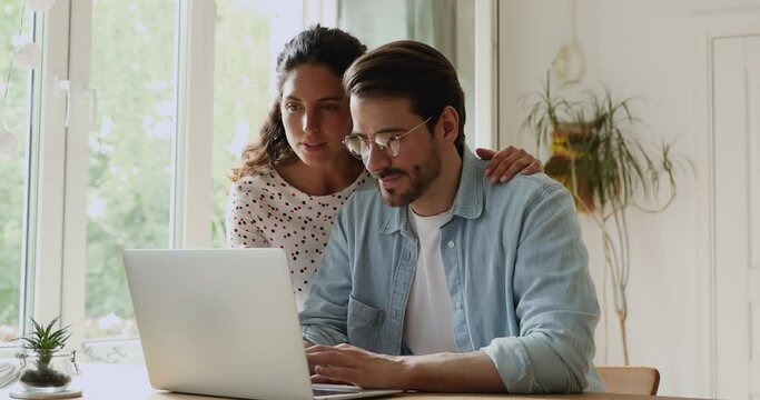 Young family happy couple use laptop read news online received great e-mail scream with joy celebrating unbelievable opportunity. Gamblers lottery monetary win, auction and betting success concept