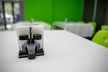 paper napkins and flowers on the table of  restaurant, close-up