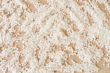 Scattered rice on a wooden table. Rice
