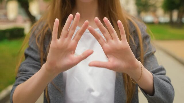 Non-verbal gestures of a young girl who clenches and unclenches her fists. Open palms. Concept on fingers count.