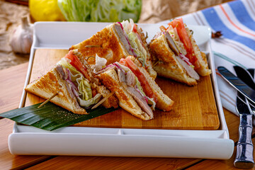 Beef and tomato sandwiches lie on a wooden Board
