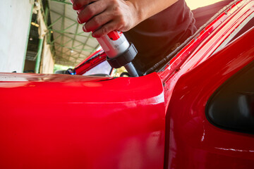 Installed the windshield, the mechanic is using a tool to apply black silicone glue to the edge of...