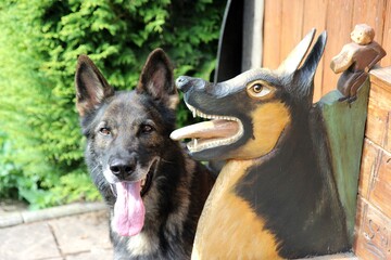 Deutscher Schäferhund mit geschnitzten Deko Hunden 