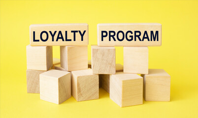 Loyalty program text on wooden blocks and on yellow table