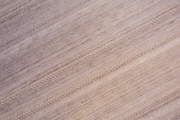 cereal field with tractor tire tracks, top down view, agricultural pattern