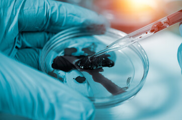 Science and medicine concept.scientist analyzing and dropping a sample into a glassware and science experiments.Laboratory glassware containing chemical liquid,