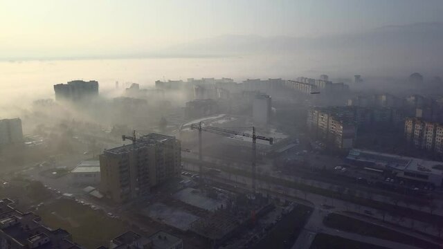 Flying over a concrete living apartment area in east Europa with many birds flying around the drone