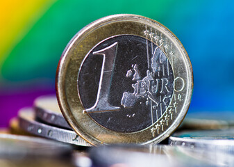 Money. 1 euro coin close up, against colorful background