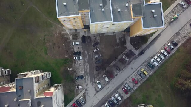 Flying over a concrete living apartment area in east Europa with many birds flying around the drone
