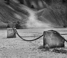 An old thick chain between rocks in an abandoned shipyard in Sweden.