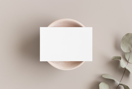 White business card mockup with a eucalyptus branch. 85x55mm