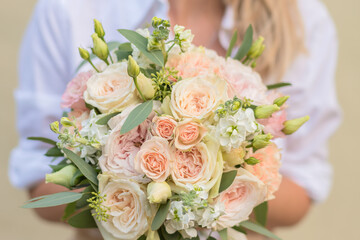 Obraz na płótnie Canvas Wedding bouquet in bride hands. Roses, eustoma, eucalyptus in elegant bouquet . Summer and autumn flowers.