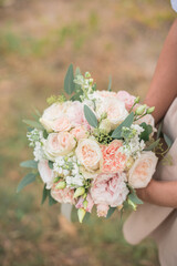 Wedding bouquet in bride hands. Roses, eustoma, eucalyptus in elegant bouquet . Summer and autumn...