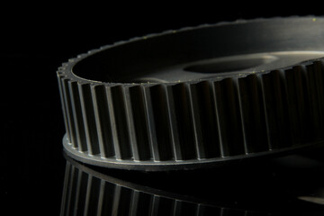 Black auto part on the dark background