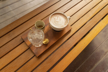 Close up of a cup of coffee, hot latte or expresso with wood table in the morning for breakfast or...