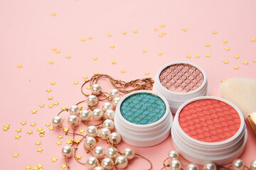 eyeshadow accessories beads makeup brushes collection professional cosmetics on pink background