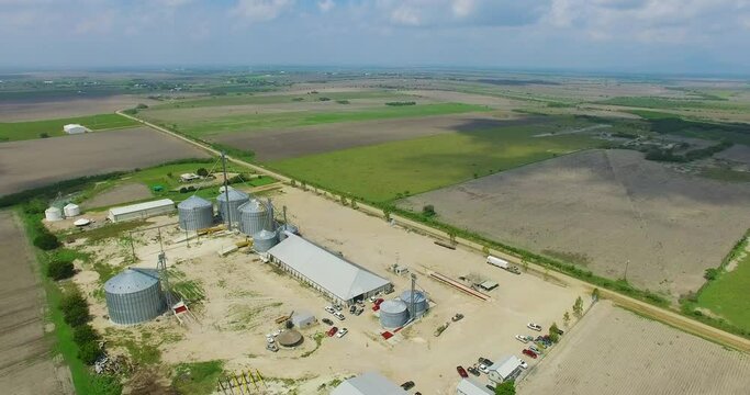 AEREAL ORBIT SHOT AROUND A GRAIN FACTORY IN DAYLIGHT