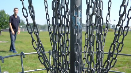 A frustrated disc golfer after a clanker off the basket close up on a summer day in the United States public course - Closeup shot on basket