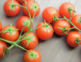 Small garden Cherrys tomatoes on the branch on wooden table