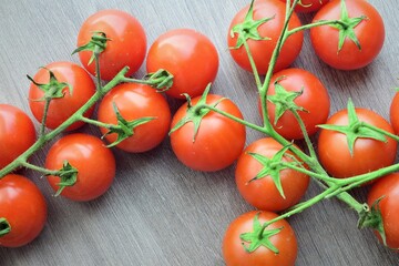 Small garden Cherrys tomatoes on the branch on wooden table