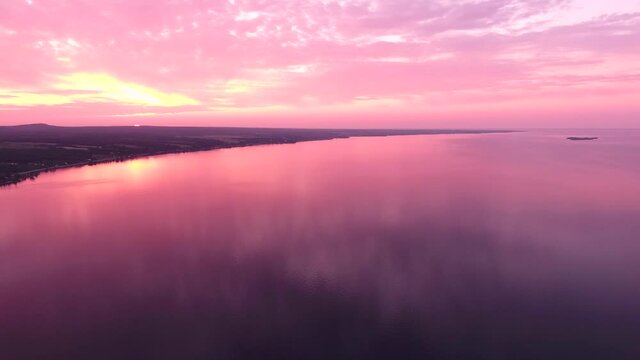 Incredible pink sunset on the Lake Saint-Jean in Canada. Filmed with a drone during summer while the water was very calm.