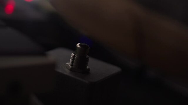 Man uses hit foot to set the tempo of the delay on his guitar effects pedal - close up shot