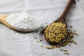 closeup of spoons with buckwheat flower and grains