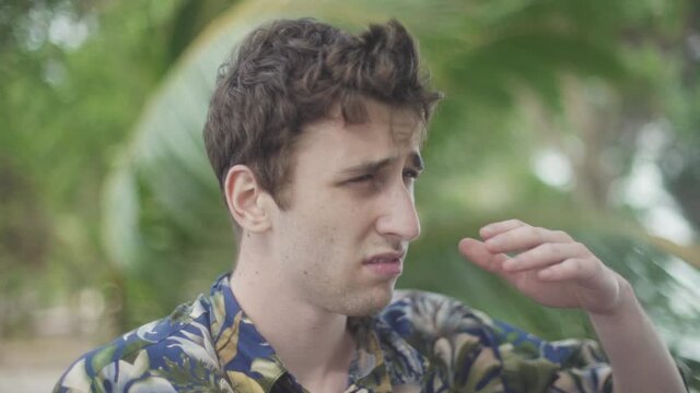Young explorer lost in tropical jungle. Scratches his head in uncertainty.