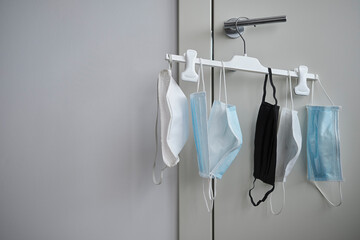 Different protective face masks hanging  with clothes