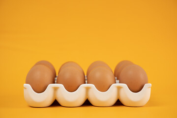 Eggs in a white egg tray on a yellow background