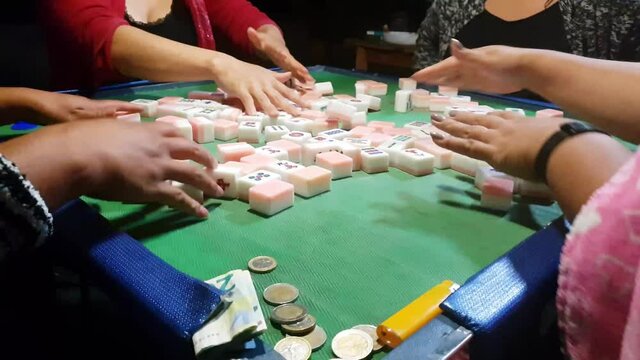 4 people playing the game Mahjong in my house.