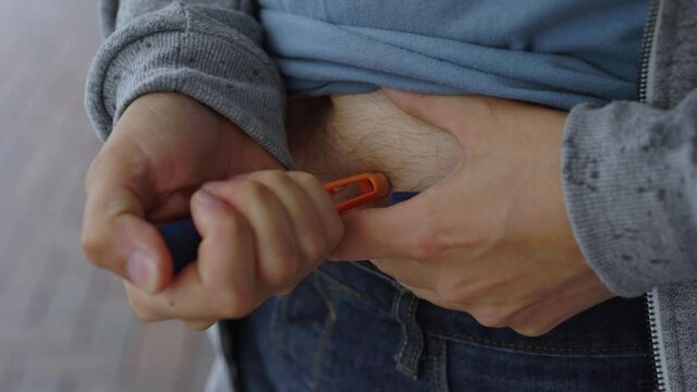 Diabetic young man doing an insulin injection on belly