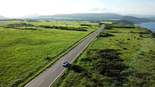 Aerial Shot Above A Two Lane Road In Taiwan Full Along The Green Coast.