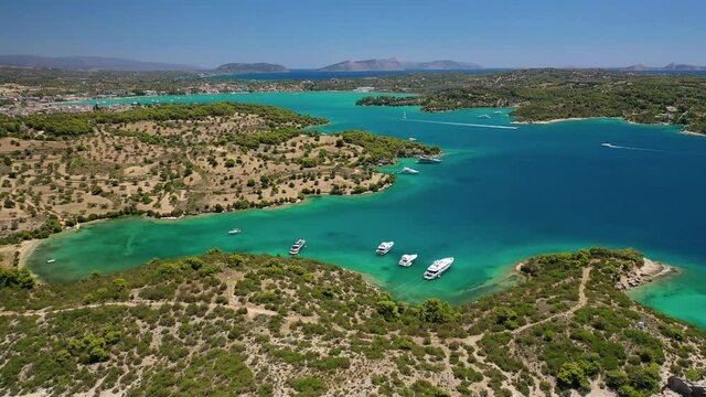 Aerial drone video of Hinitsa island bay a popular anchorage crystal clear turquoise sea bay for yachts and sailboats next to Porto Heli, Saronic gulf, Greece