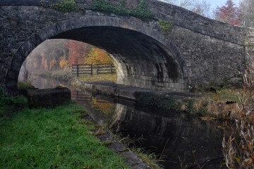 Fototapeta na wymiar Old Bridge at Foggy Canal