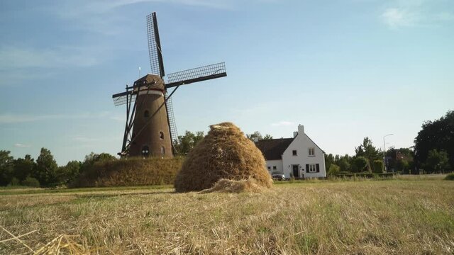 Peaceful Dutch Windmill with a traditional hay bale - Slider / Wide Shot -
