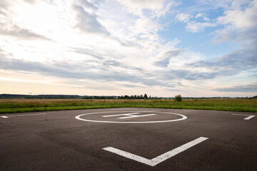 Fototapeta premium Hard surface for helicopter landing. Symbol for precise helicopter landing in the center. Evening landscape
