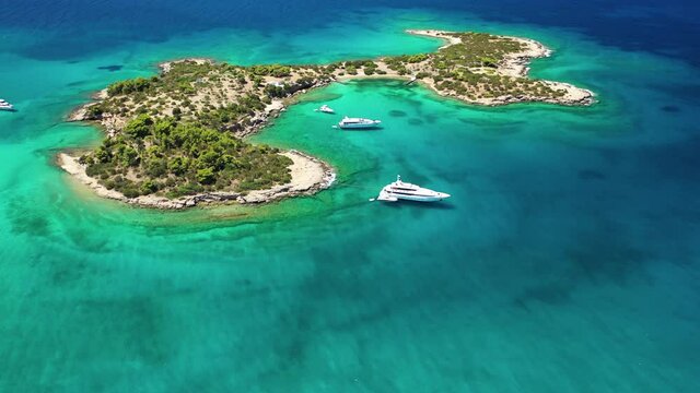 Aerial drone video of Hinitsa island bay a popular anchorage crystal clear turquoise sea bay for yachts and sailboats next to Porto Heli, Saronic gulf, Greece