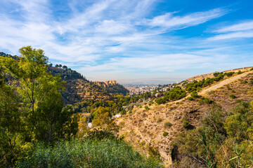 Fototapeta na wymiar Granada, Spain. 10-18-2020. Panoramic view from the Valparaíso hill, located east of Granada. In the distance, on the left, the buildings of the Alhambra. On the right the Albaícin neighborhood.