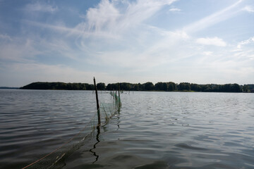 Beautiful scenery of a fishing net in a lake one of the latest days of summer. Picture from Ringsjon, Scania, southern Sweden. Blue sky meets blue water