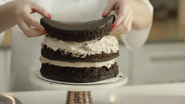 Woman builds a chocolate layer cake