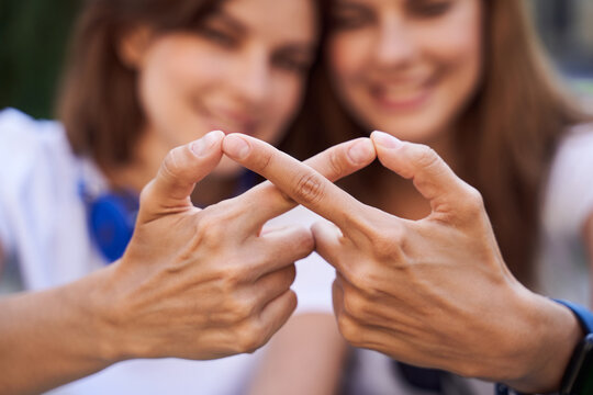 Girls Hands Representing The Sign Infinity