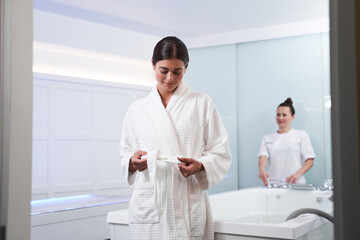 Woman ties a bathrobe after spa