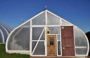 Fototapeta na wymiar Plastic greenhouse against blue sky