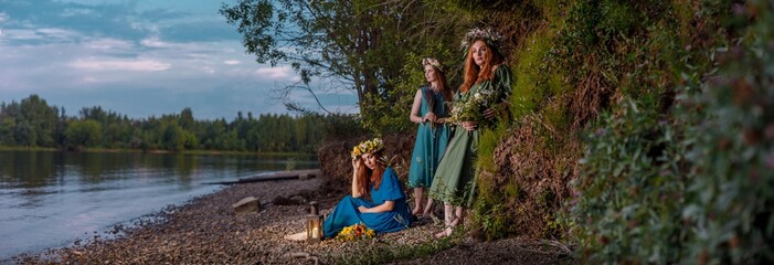 Lovely girls in flower wreaths in nature. Ancient pagan origin celebration concept. Summer solstice day. Mid summer. Ancient rituals.